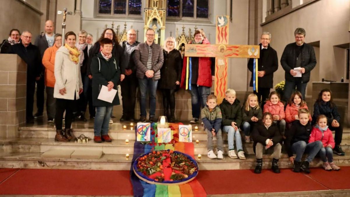 Das Team des Friedensgebets, neben dem Friedenskreuz von Werner Hesse. von privat