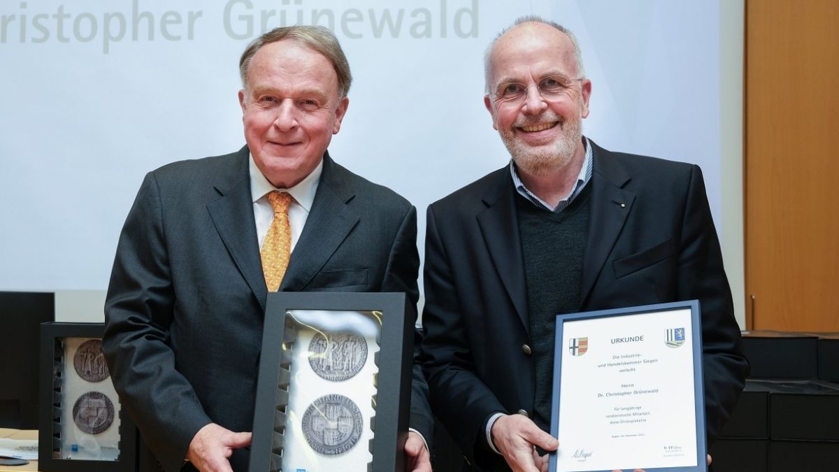 Verleihung der Ehrenplakette: IHK-Präsident Walter Viegener (links) gratuliert Dr. Christopher Grünewald. von IHK Siegen