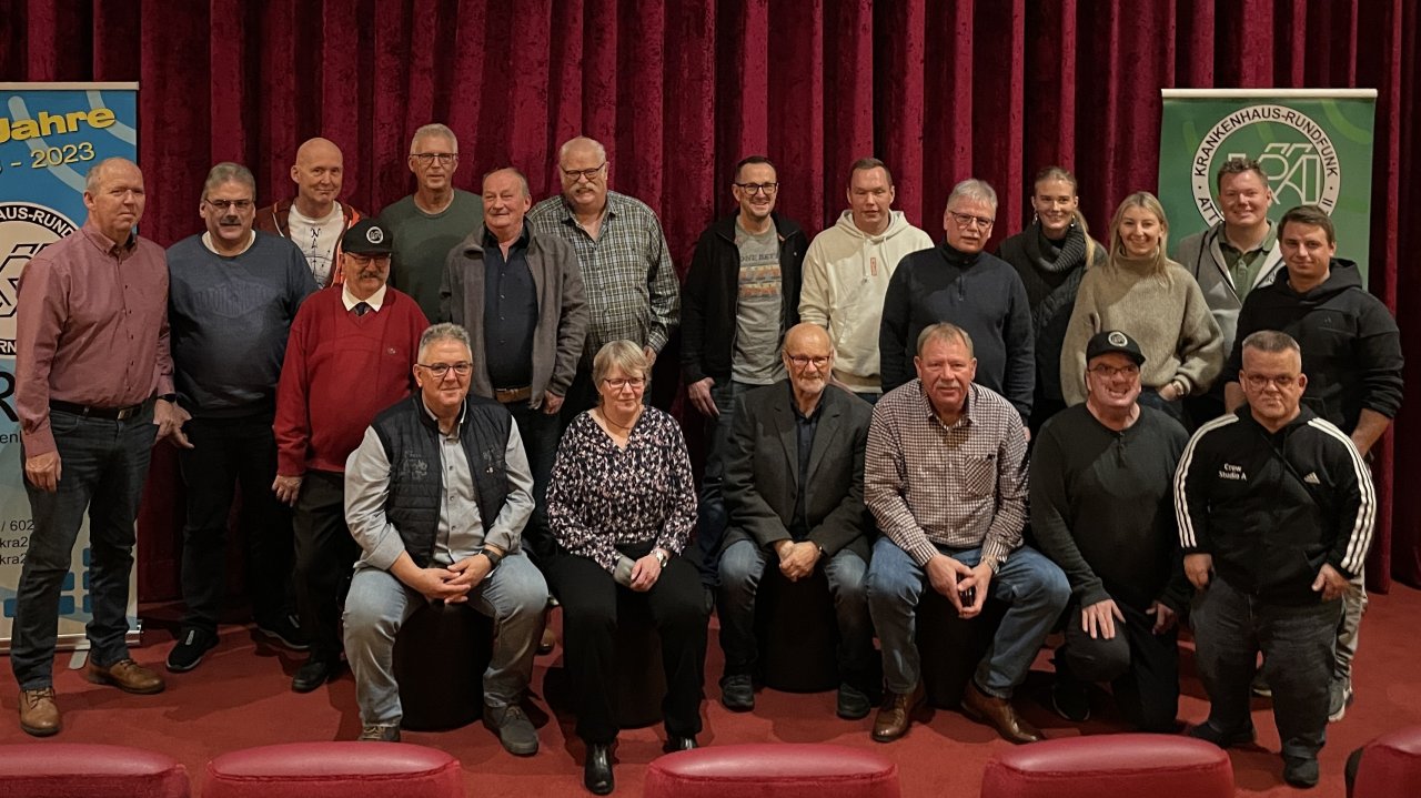 Das aktuelle Team des Krankenhausrundfunks mit Studioleiter Marvin Weber (Zweiter von rechts, hinten) und ehemaligen Mitarbeitern, darunter Gründungsvater Friedhelm Hoffmann (Vierter von rechts, vorne), bei der Jubiläumsfeier im JAC Kino Attendorn. von KRA 2