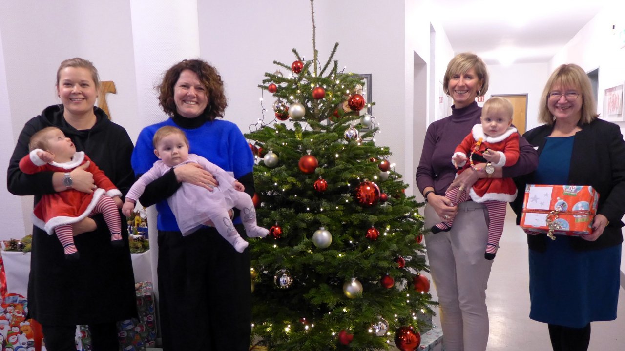 Die symbolische Übergabe der 160 Geschenke durch Sylvia Gante, Bereichsleiterin Vorstandsstab bei der Sparkasse Attendorn-Lennestadt-Kirchhundem, (rechts) an die Leiterin des „Haus Aline“, Marion Weidlich (Zweite von links), sowie zwei ihrer Mitarbeiterinnen mit Chayenne, Allessa und Emilia (von links). von privat