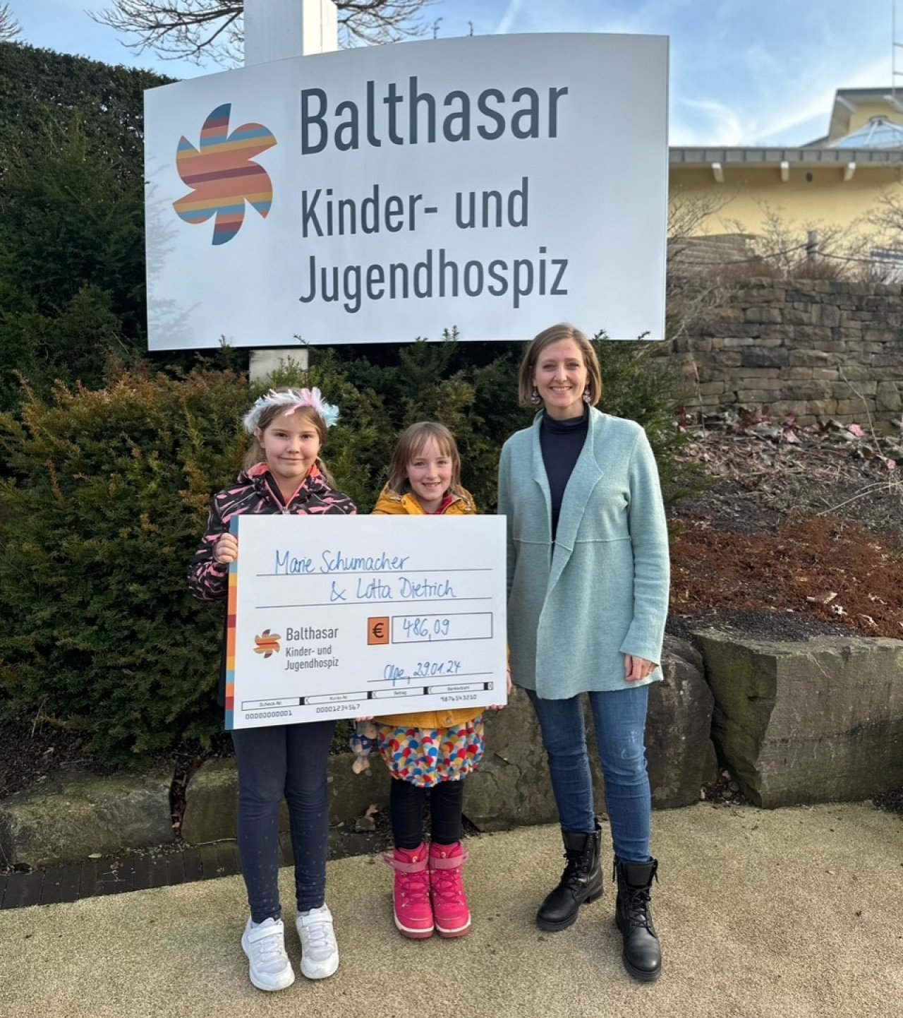 Die beiden Mädchen übergeben den Spendenscheck an Carolin Allmendinger vom Kinder- und Jugendhospiz Balthasar. von privat