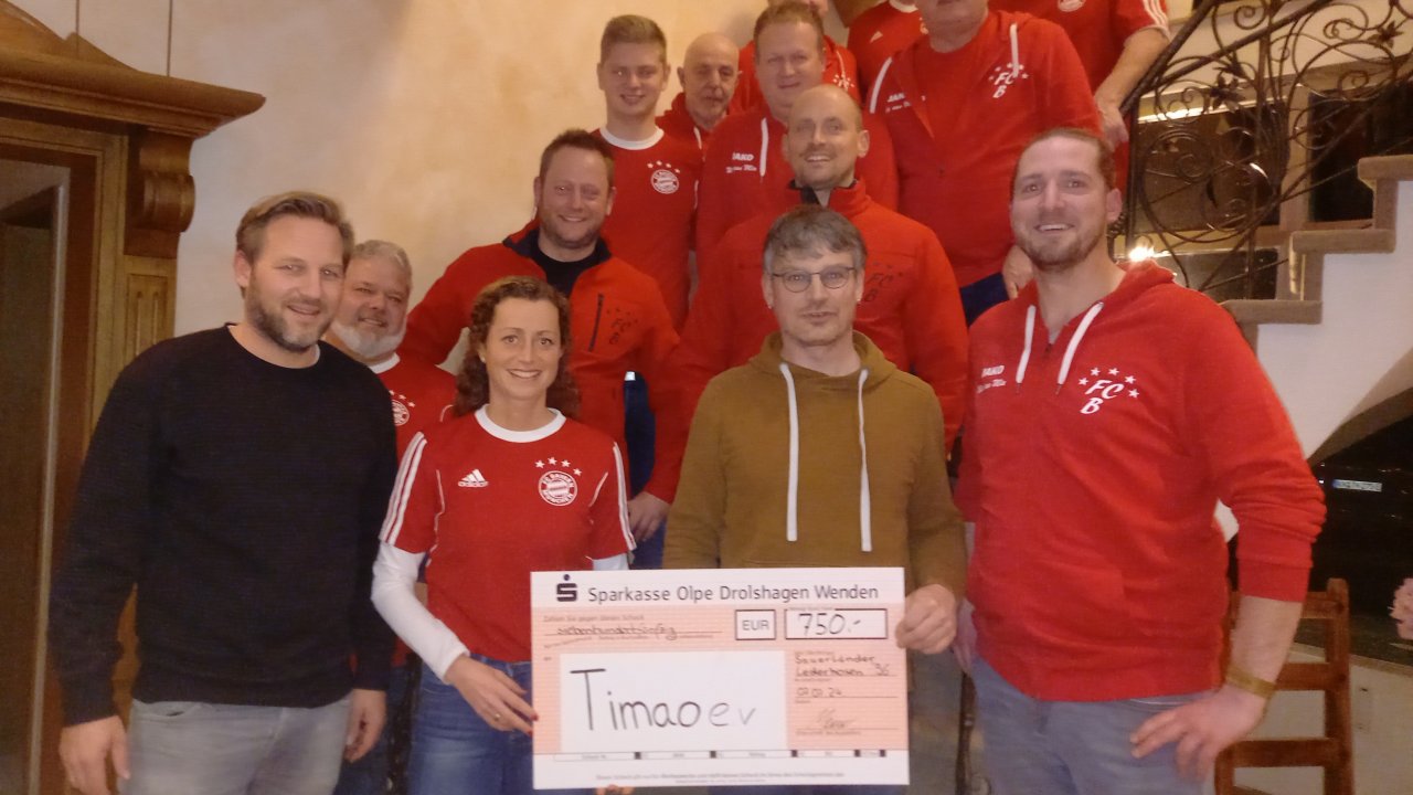 Der Fanclub „Sauerländer Lederhosen“ überreichte den symbolischen Spendenscheck an Vertreter des Projekts TIMAO. von privat