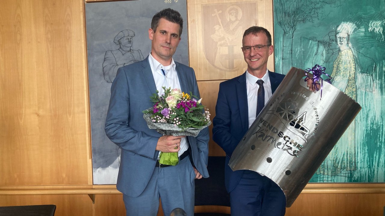 Markus Hohmann (links), Fachbereichsleiter Bauen und Stadtentwicklung, verlässt nach acht Jahren die Gemeinde Wenden. Zum Abschied überreichte Bürgermeister Bernd Clemens einen Blumenstrauß und eine Feuertonne mit Kirmes-Logo. von Lorena Klein