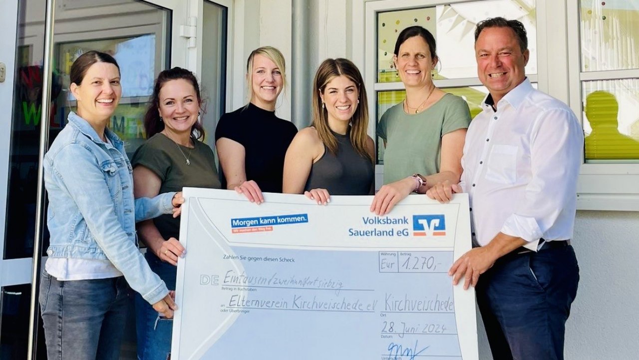 Volksbank-Unternehmenssprecher Frank Segref überreicht den Scheck an (v.l.) Sarah Kramer (Leitung), Christin Hüttermann, Petra Vogt, Laura Gerspers (alle Vorstand Elternverein) und Carolin Epe (Leitung). von privat