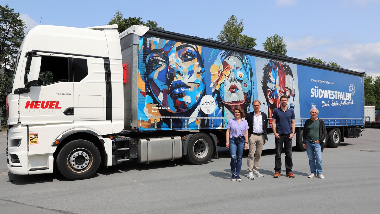 Von links: Christoph Heuel (Geschäftsführer Heuel Logistics, Künstler Jack Mason, dessen Bilder präsentiert werden, sowie Patrick Bonzel, der den Lkw bei der Südwestfalen Agentur GmbH grafisch umgesetzt hat. von Julia Manderbach, Südwestfalen Agentur GmbH