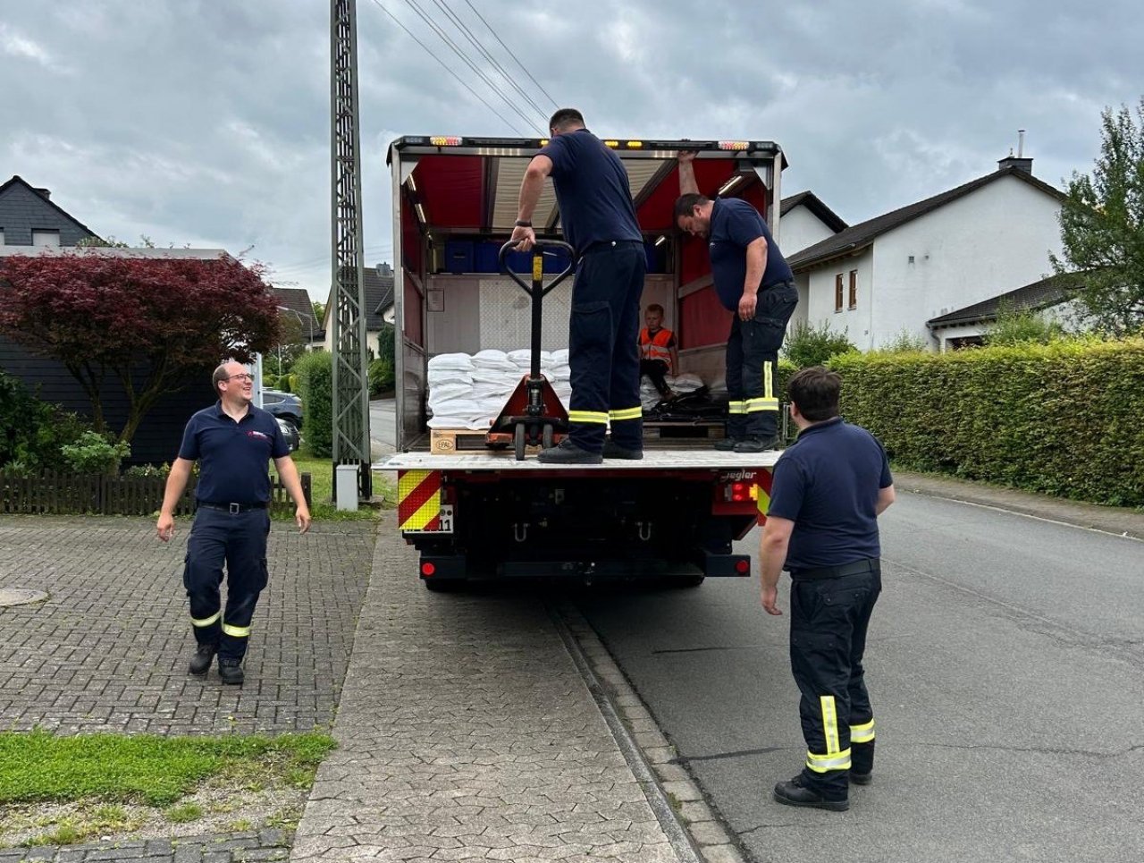 Einsatzkräfte der Feuerwehr Wenden und des THW Olpe befüllten und verteilten gemeinsam 700 Sandsäcke für die Ottfinger. von Feuerwehr Wenden
