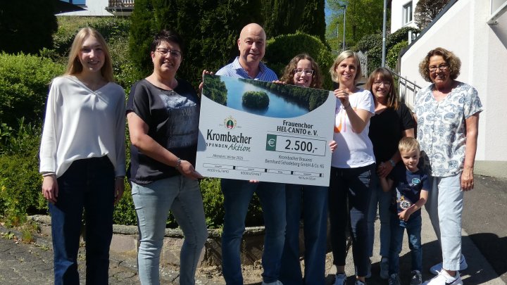 Krombacher Gebietsverkaufsleiter Rainer Brüser überreicht den symbolischen Scheck.