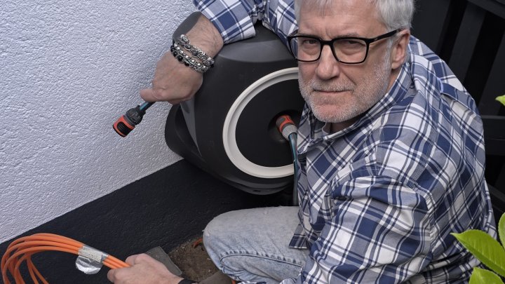 Reinhard Schönauer mit dem Glasfaserkabel, das an der Hauswand liegt, aber seit zwei Jahren immer...