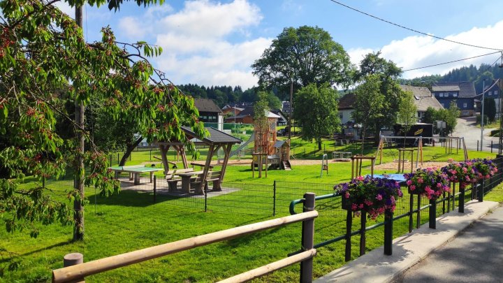 Blick auf den Spielplatz mit seinen neuen Geräten und Sitzgelegenheiten.