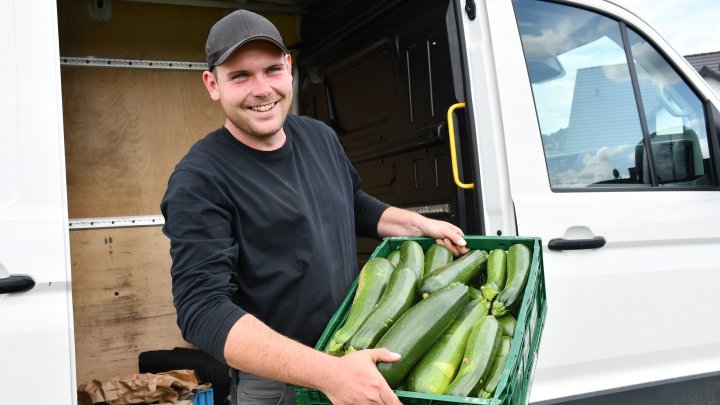 Max Steinberg mit einer Kiste frisch geernteter Zucchini auf dem Weg zu seinem Kühlhaus.