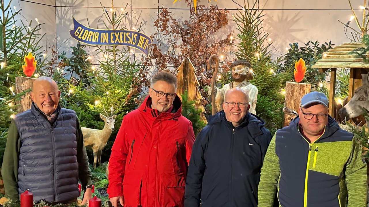 Reinhard Hesse, Vorsitzender der Dorf-AG, Pater Siegfried Modenbach, Ansgar Kaufmann (Pfarrgemeinderat) und Michael Becker, 2. Vorsitzender Dorf-AG (v.l.), am Adventskranz vor der Krippe. von privat