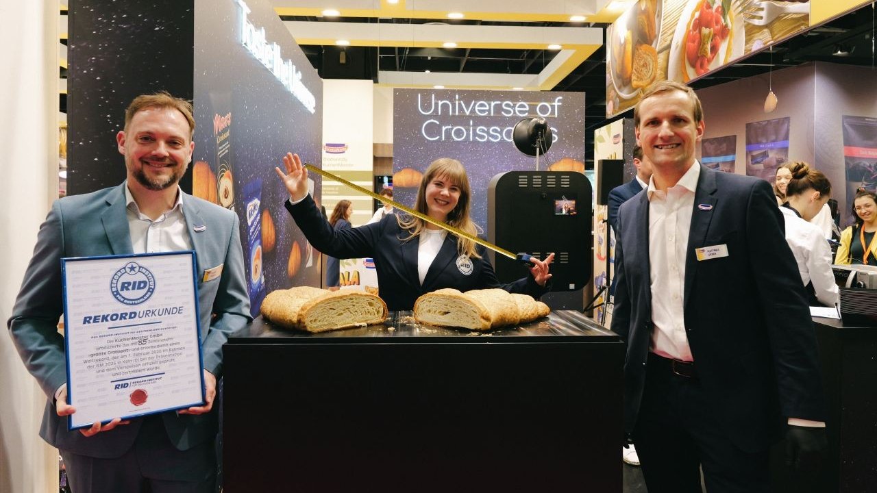 V.l.: Fabian Meiberg (Head of Business Development, Sales & Marketing, KuchenMeister), Laura Koblischek (RID) und Matthias Weber (KuchenMeister) mit dem Weltrekord-Croissant. von StudioHub
