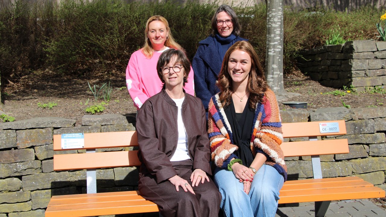 Bei der Pressekonferenz des Netzwerks gegen häusliche Gewalt (v.l.): Simone Klewes, Anette Pfeifer (hinten), Sabine Nosiadek und Vanessa Dorn (vorne) an einer der orangefarbenen Bänke, die ein Zeichen gegen Gewalt an Frauen und Mädchen setzen. von Lorena Klein
