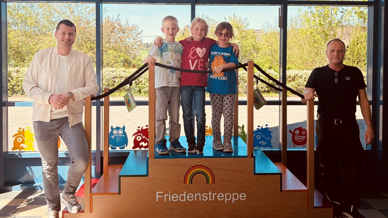 Die Grundschüler der Oene-Elspe-Tal-Schule freuen sich über die neuen Friedenstreppe. Ein Dank geht an Danny Christopher Remmen von der Firma H&R Spezialfedern (l.) sowie Michael Schulte, Schreiner aus Grevenbrück. von privat