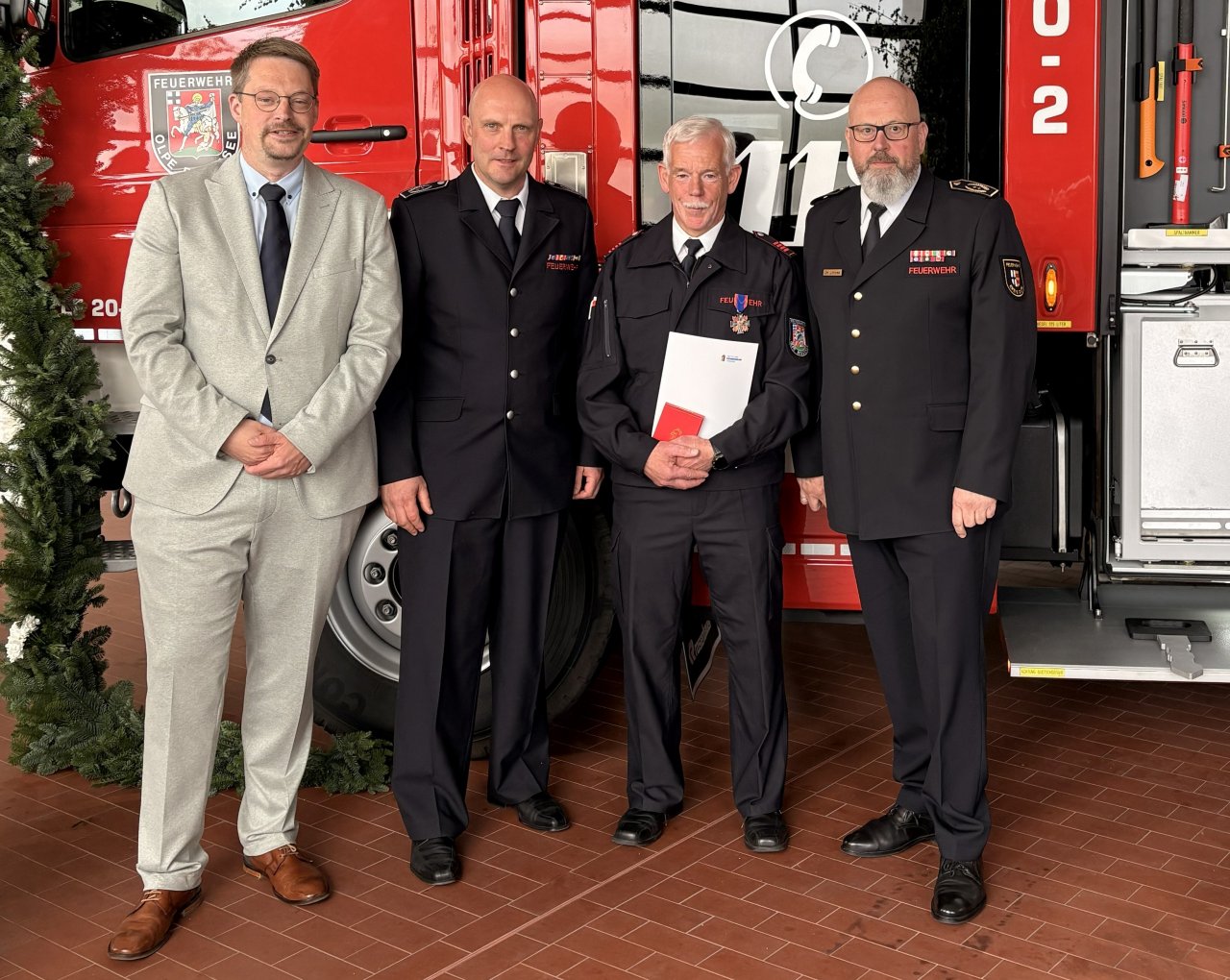 Kreisbrandmeister Christoph Lütticke (r.) ehrte Unterbrandmeister Burkhard Wigger (2.v.r.) mit dem Deutschen Feuerwehr-Ehrenkreuz in Bronze. von Feuerwehr Olpe