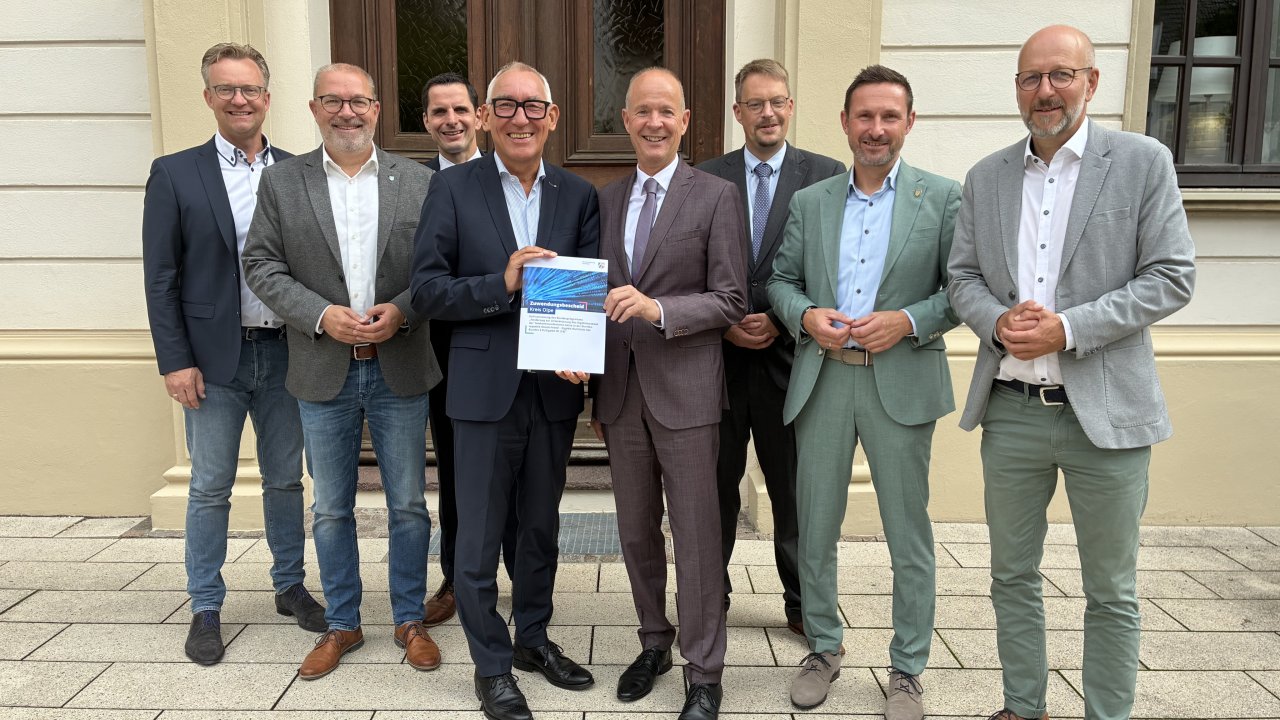 Regierungspräsident Heinrich Böckelühr (4. v.l.) überreicht Landrat Theo Melcher (4. v.r.) den Bewilligungsbescheid für den geförderten Glasfaserausbau im Kreis Olpe. Darüber freuen sich auch die Bürgermeister (v.l.) Tobias Puspas (Lennestadt), Achim Henkel (Finnentrop) und Christian Pospischil (Attendorn) sowie (v.r.) Uli Berghof (Drolshagen), Björn Jarosz (Kirchhundem) und Tobias Schulte (Olpe). Foto: Hansestadt Attendorn. von Hansestadt Attendorn