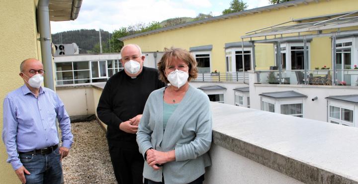 Martin Schäfer, Pastor Heinrich Schmidt und Monika Kramer (v.l.) im Außenbereich des linken Hospizflügels: Rechts ist das jetzige Hospiz zu sehen, die freie Fläche im Hintergrund wird überbaut, die Räume werden dadurch vergrößert.