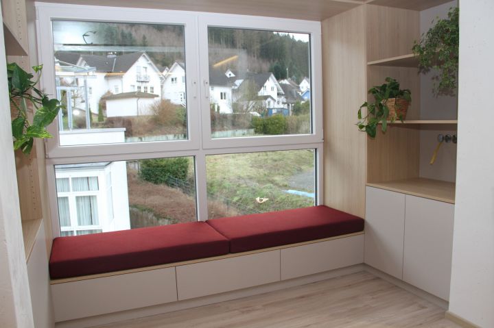 Die Leseecke vor dem großen Fenster im Wohnzimmer wird noch mit dicken Kissen ausgestattet.