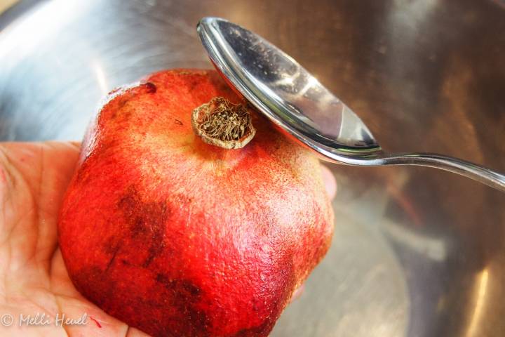 Granatapfel halbieren, mit der Schnittseite in die Hand legen und mit einem Löffel auf den Granatapfel klopfen. So lösen sich die Kerne ideal.