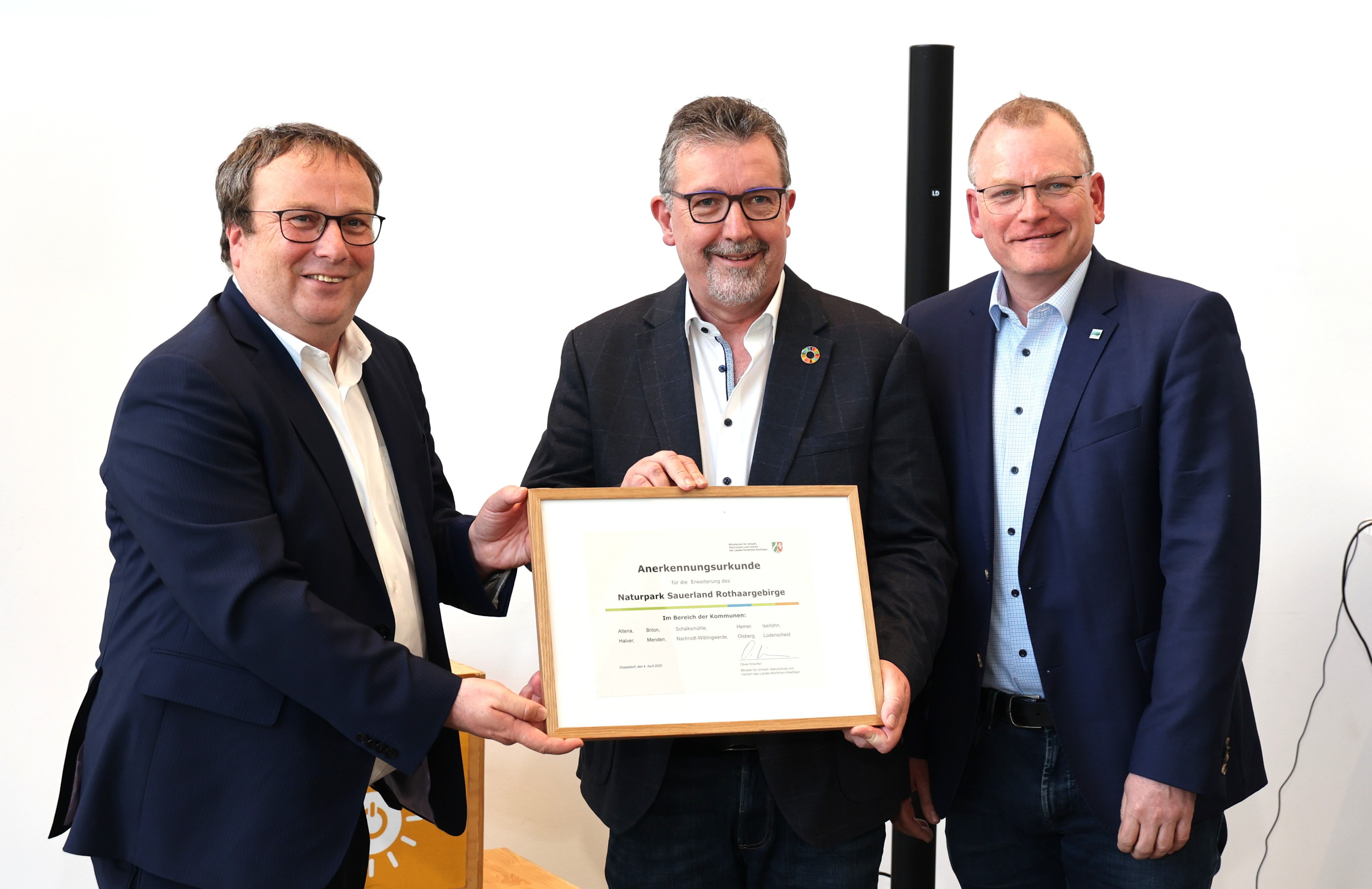 Bernd Fuhrmann (Mitte), Vorsitzender Naturpark Sauerland Rothaargebirge, und Detlef Lins (r.), Geschäftsführer des Naturparks, nehmen mit Freude die Urkunde zur Flächenerweiterung von Minister Oliver Krischer (l.) entgegen. von Nasser Trabulsi