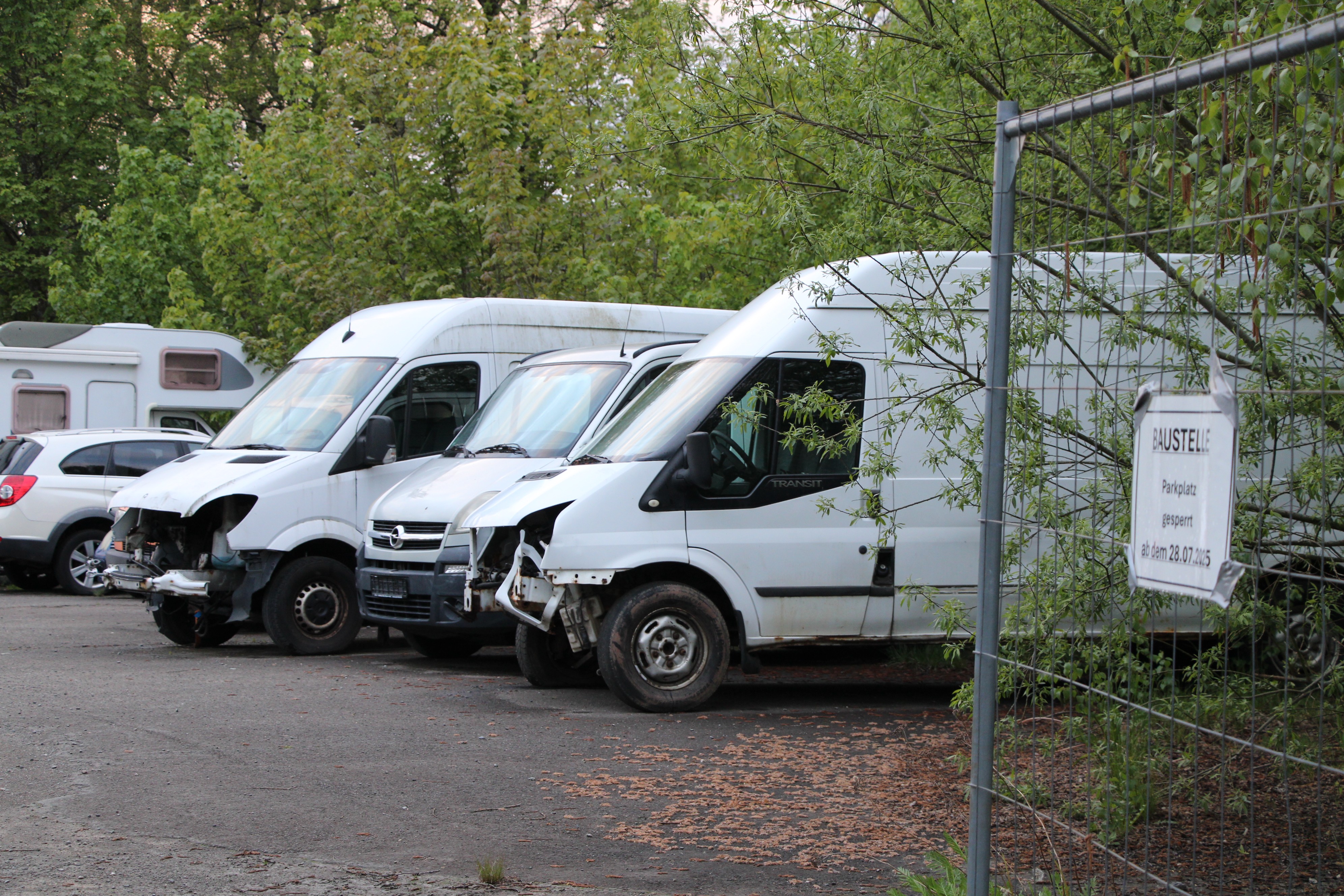 Auf dem ehemaligen Mitarbeiter-Parkplatz soll ein Wohnquartier entstehen. Momentan stehen hier einige Unfallwagen. von Lorena Klein